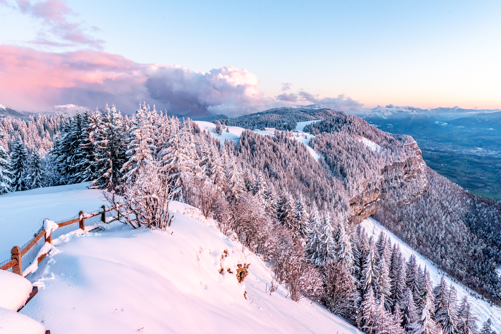 montagne enneigée avec le soleil couchant donnant des teintes roses